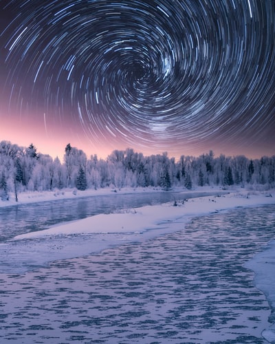 时间流逝摄影在夜间星星上面的水域
